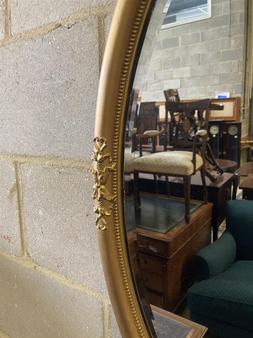 An early 20th century oval gilt framed wall mirror, width 55cm height 80cm